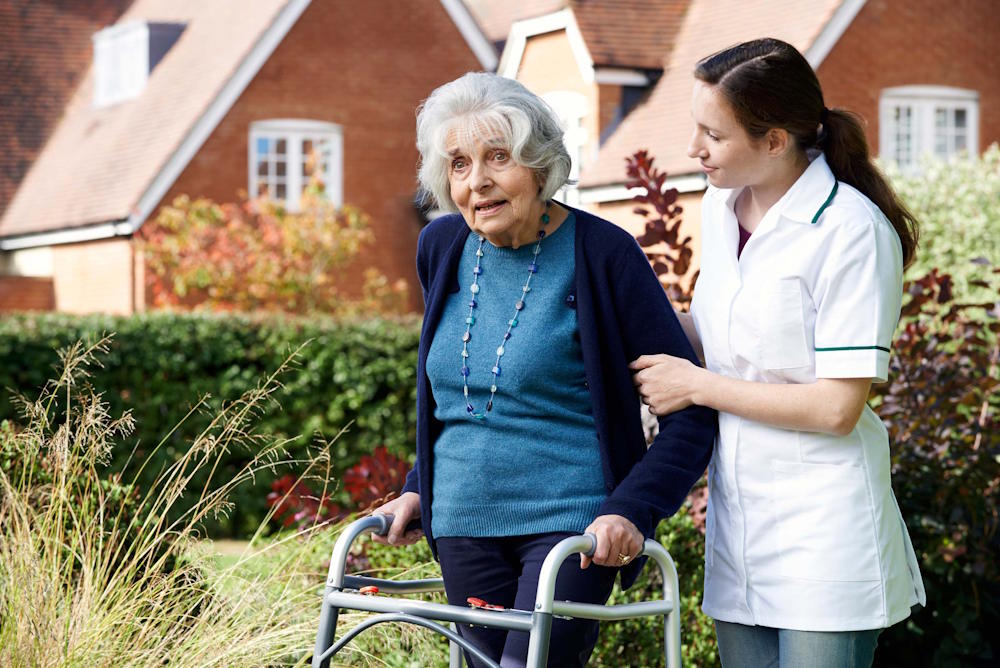 carer helping senior walk